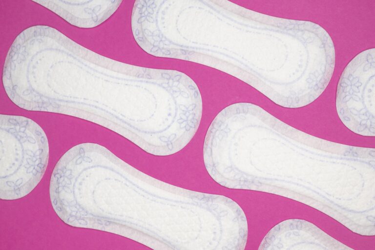 Menstrual health products and supplies (pads, tampons, menstrual cups or reusable cups) on a colorful background.